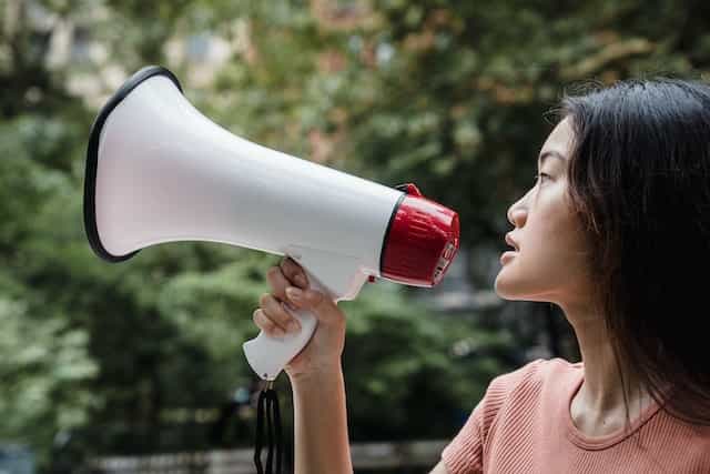 Seorang wanita berbicara ke megafon.