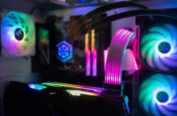 The inside of a high-end gaming computer, featuring several multicolored fans, the computer’s processor, graphics card, and other hardware.