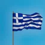 Greek flag against a clear sky.