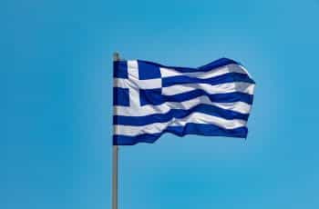 Greek flag against a clear sky.