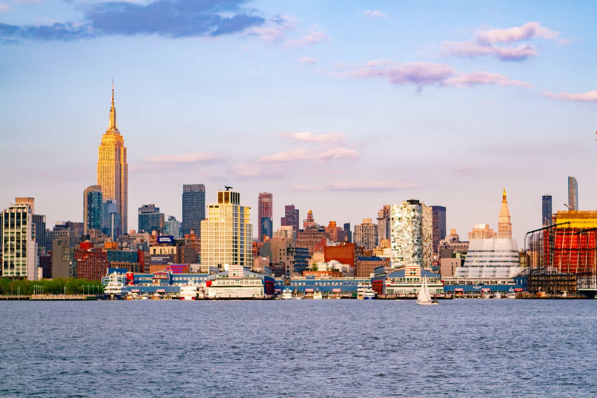 Cakrawala sebuah kota di New Jersey seperti yang terlihat dari trotoar Manhattan di New York City, New York, menampilkan beberapa gedung pencakar langit dan gedung-gedung tinggi serta menara.