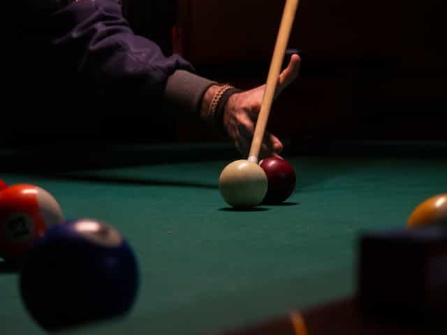 Bola snooker di atas meja hijau.