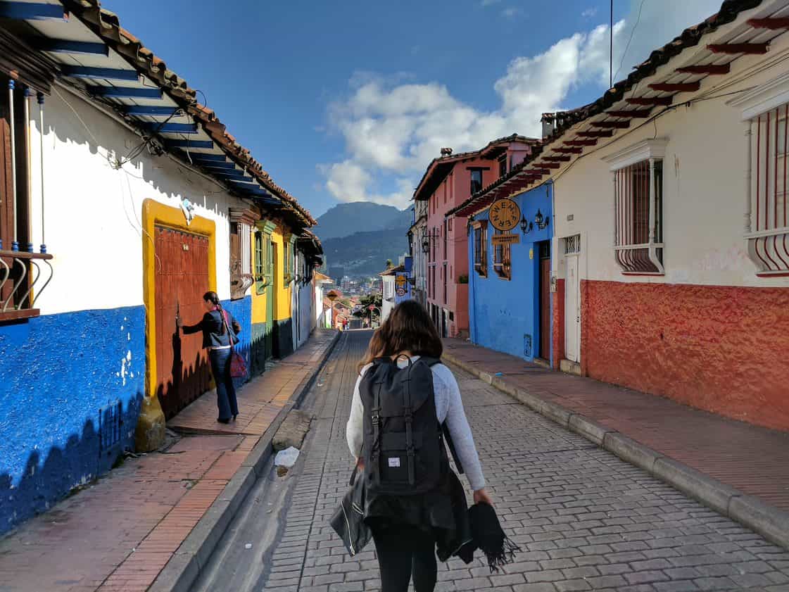 A woman walks down a small street in Bogotá, Colombia.