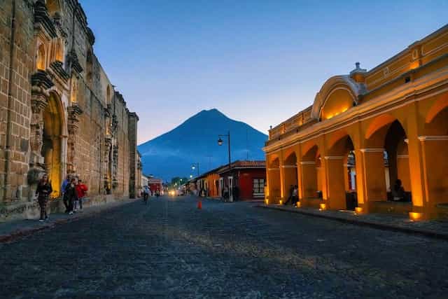 Bangunan kuno dengan latar belakang gunung di Bulevar Villa Deportiva, Guatemala.
