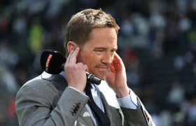 Presenter Simon Thomas holding a Sky Sport microphone.