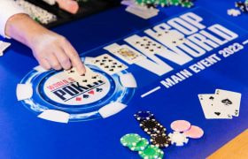 Players sit around a World Series of Poker branded table.