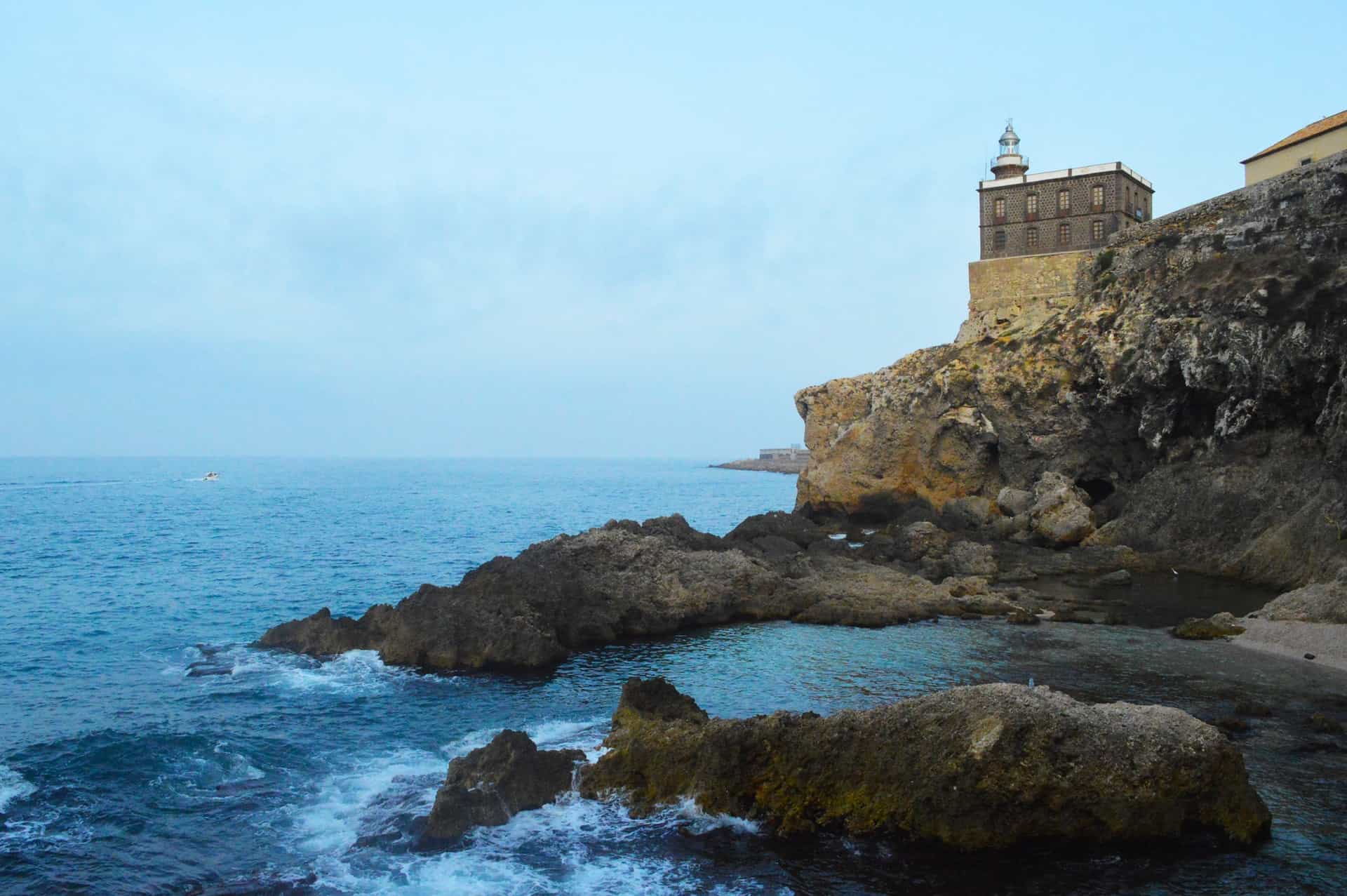 Landmark buildings on rock cliffs over the ocean in Melilla, Spain.