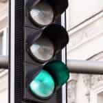 A traffic light in the street showing a green light.