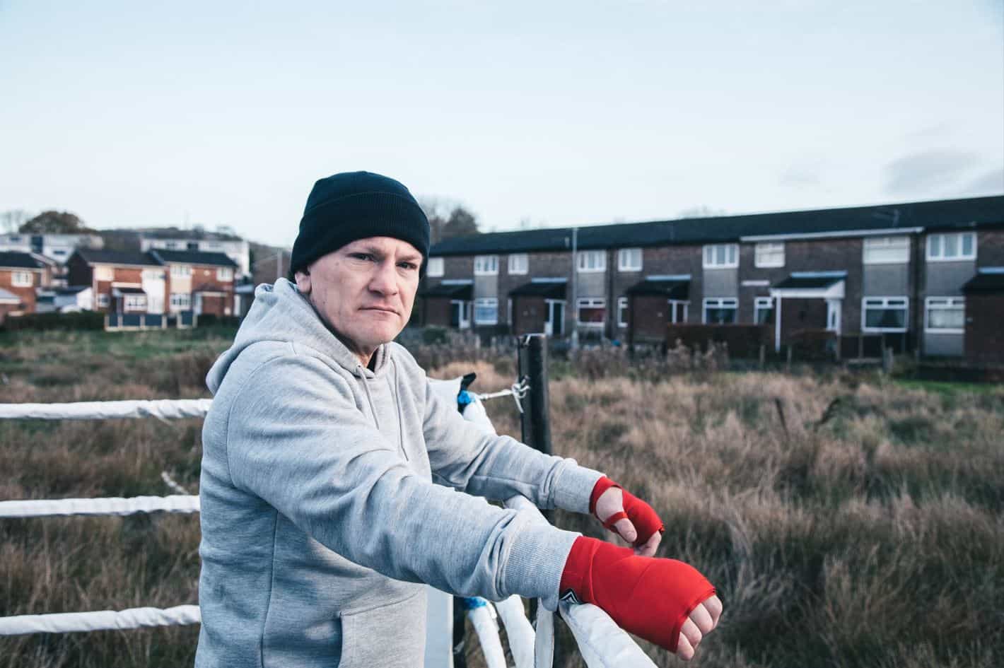 Ricky Hatton looking out onto a bleak housing estate. 
