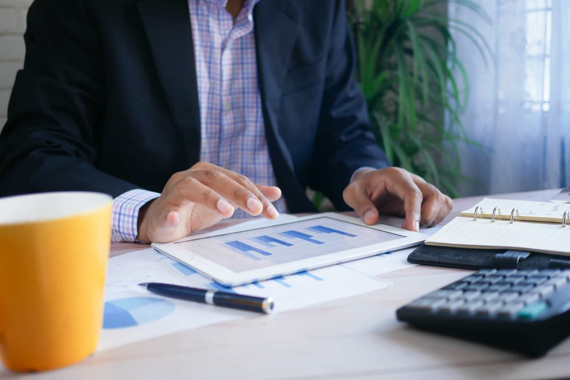 A man crunching numbers with graphs and a calculator.