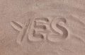The word “yes” drawn into the sand on a beach or in a desert.