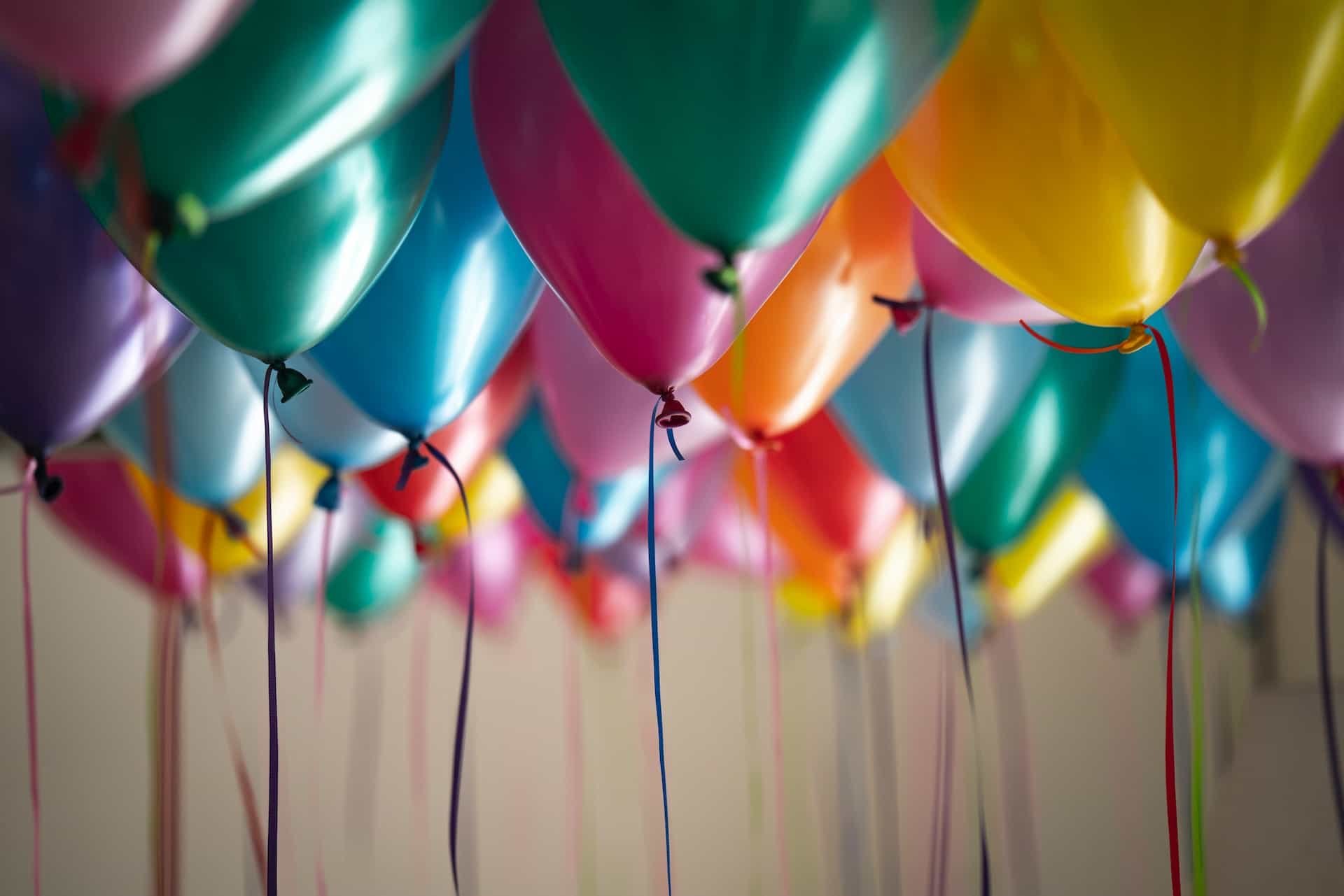 Colorful balloons attached to strings.