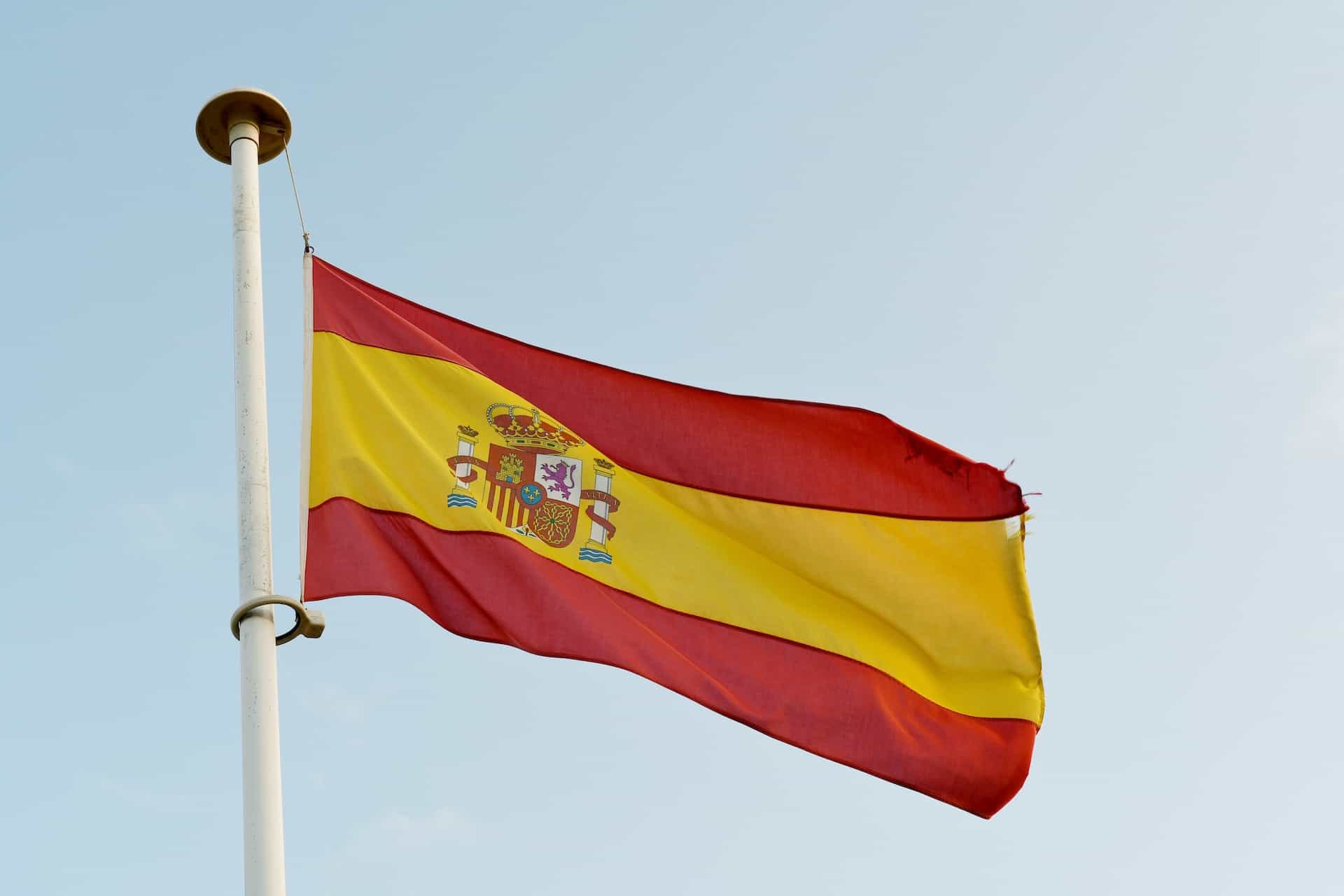 The Spanish flag waves on a flagpole.