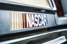 The world-famous NASCAR logo emblazoned on a bumper sticker placed on the back of a car.