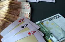 Chips, cash and aces on a poker table.