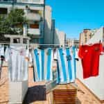 Various soccer jerseys from national teams hang on a washing line.