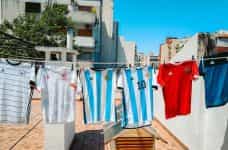 Various soccer jerseys from national teams hang on a washing line.
