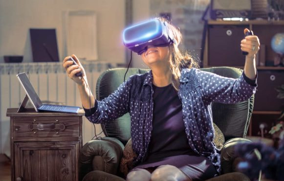 A smiling woman trying a virtual reality headset.