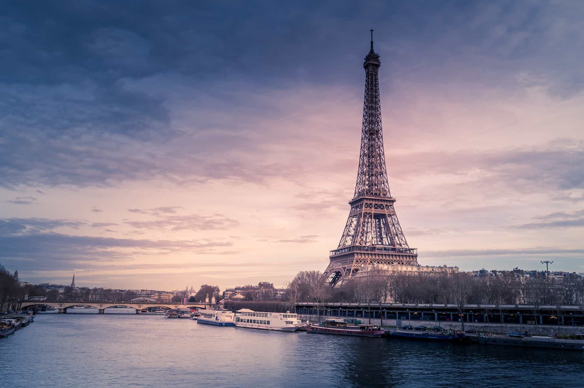 A picture of the Eiffel Tower from the banks of a river.