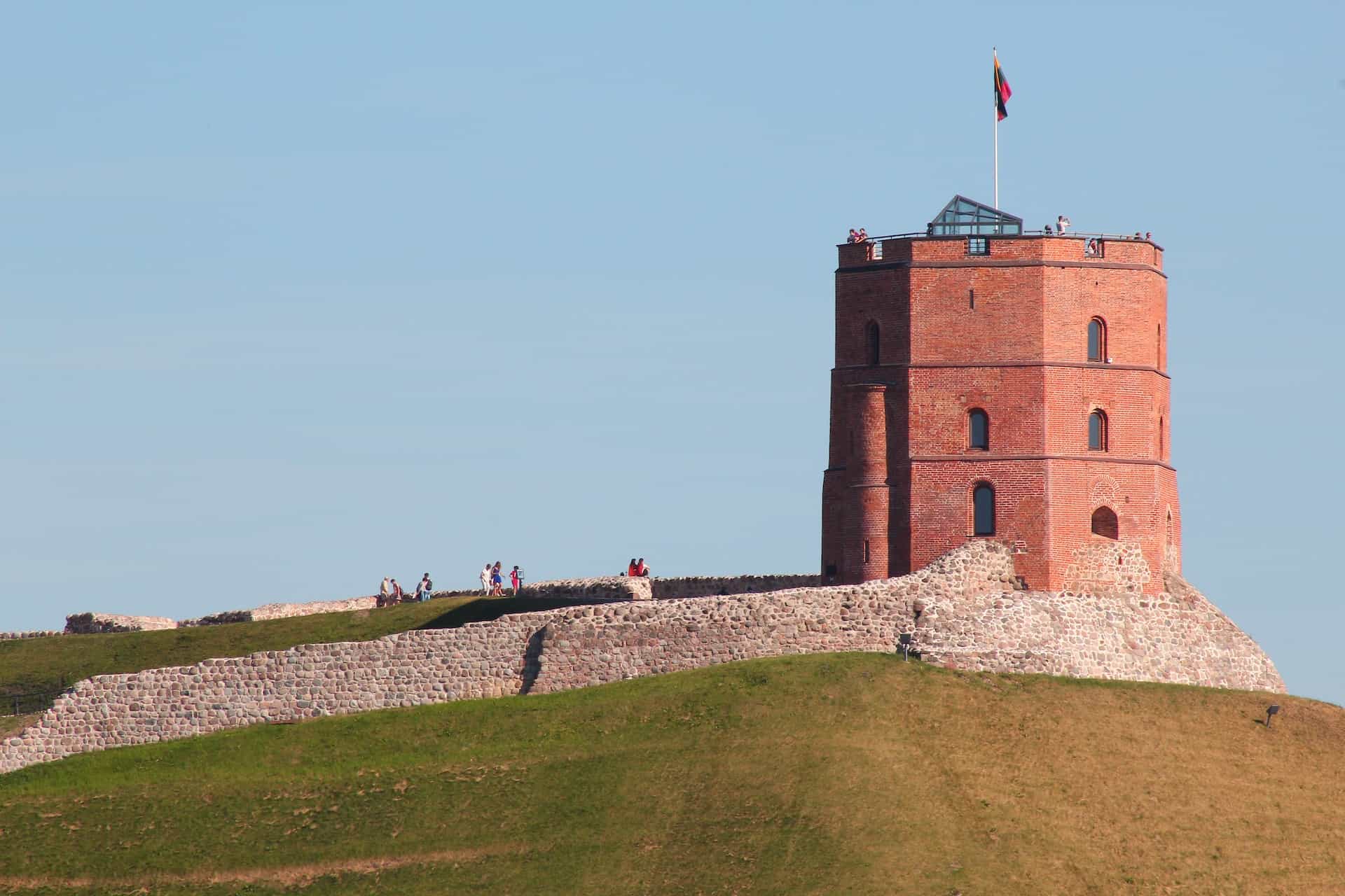 A giant brick tower on top of a green hill.