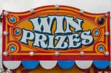 A carnival sign reads WIN PRIZES in yellow and red paint.