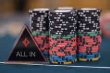 Chips and an ‘All IN’ dealer button on a poker table.