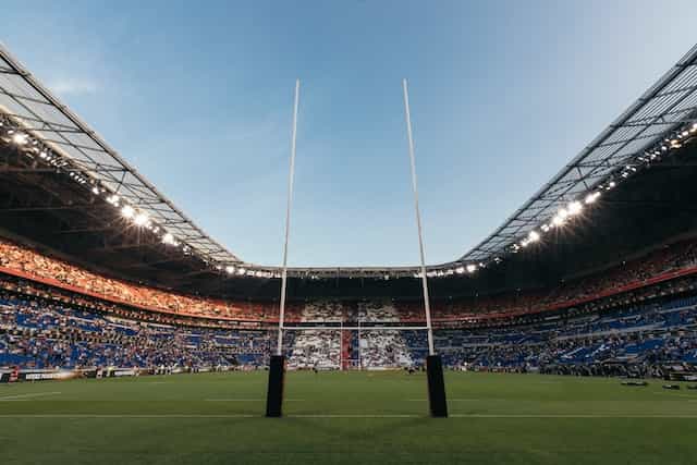 Two rugby goal posts in a large stadium.