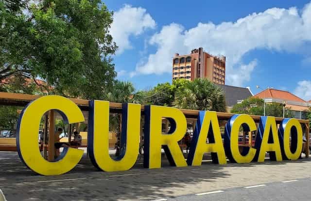 A large yellow sign spells out the name Curaçao in the city of Willemstad, Curaçao.