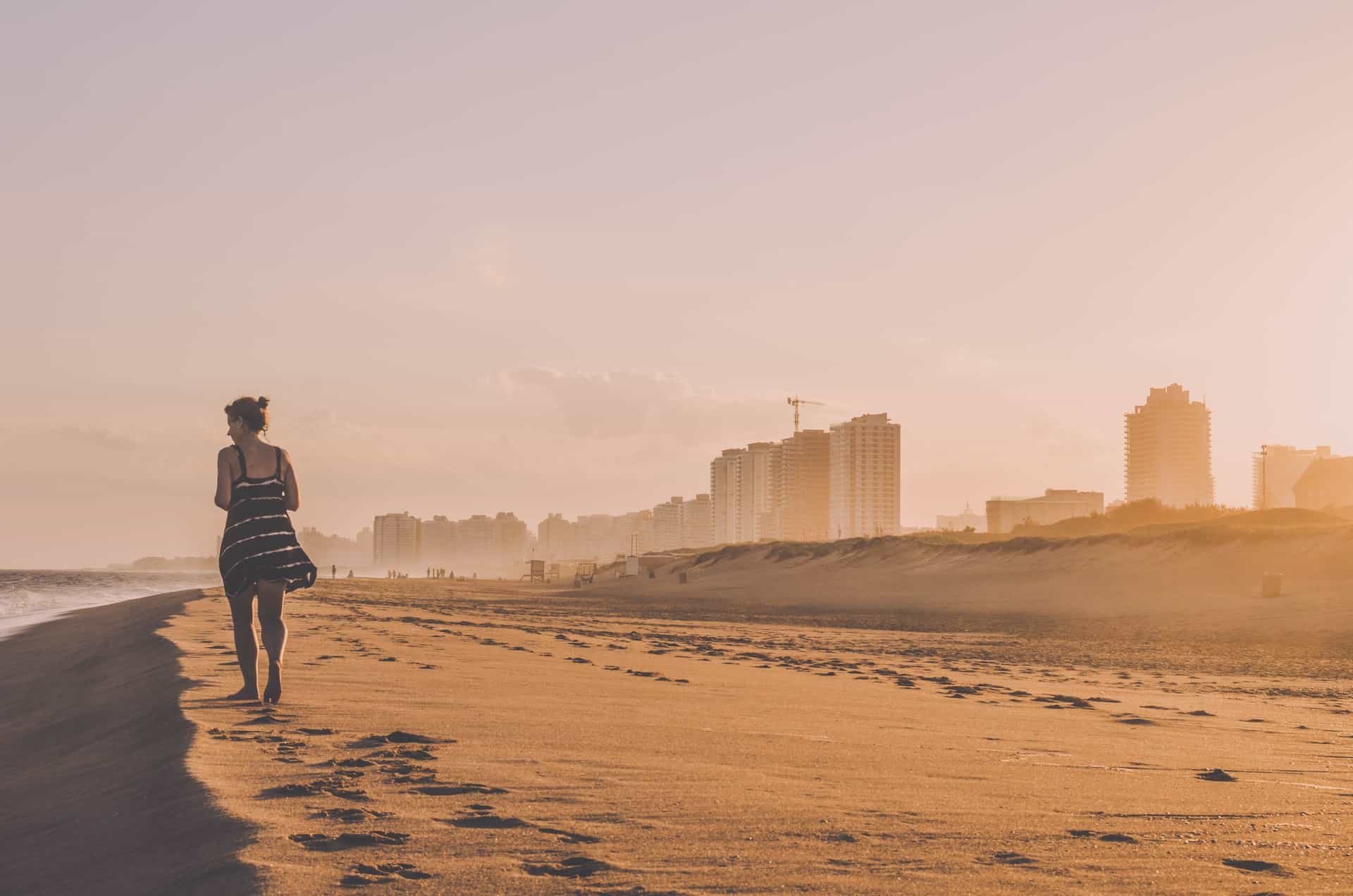 A woman walking along a sandy beach at Punta del Este, Uruguay.