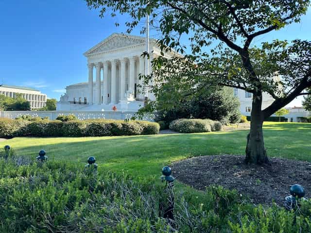 The world-famous United States Supreme Court in the nation’s capital, Washington, D.C., featuring a small slice of its garden to the side of the building.