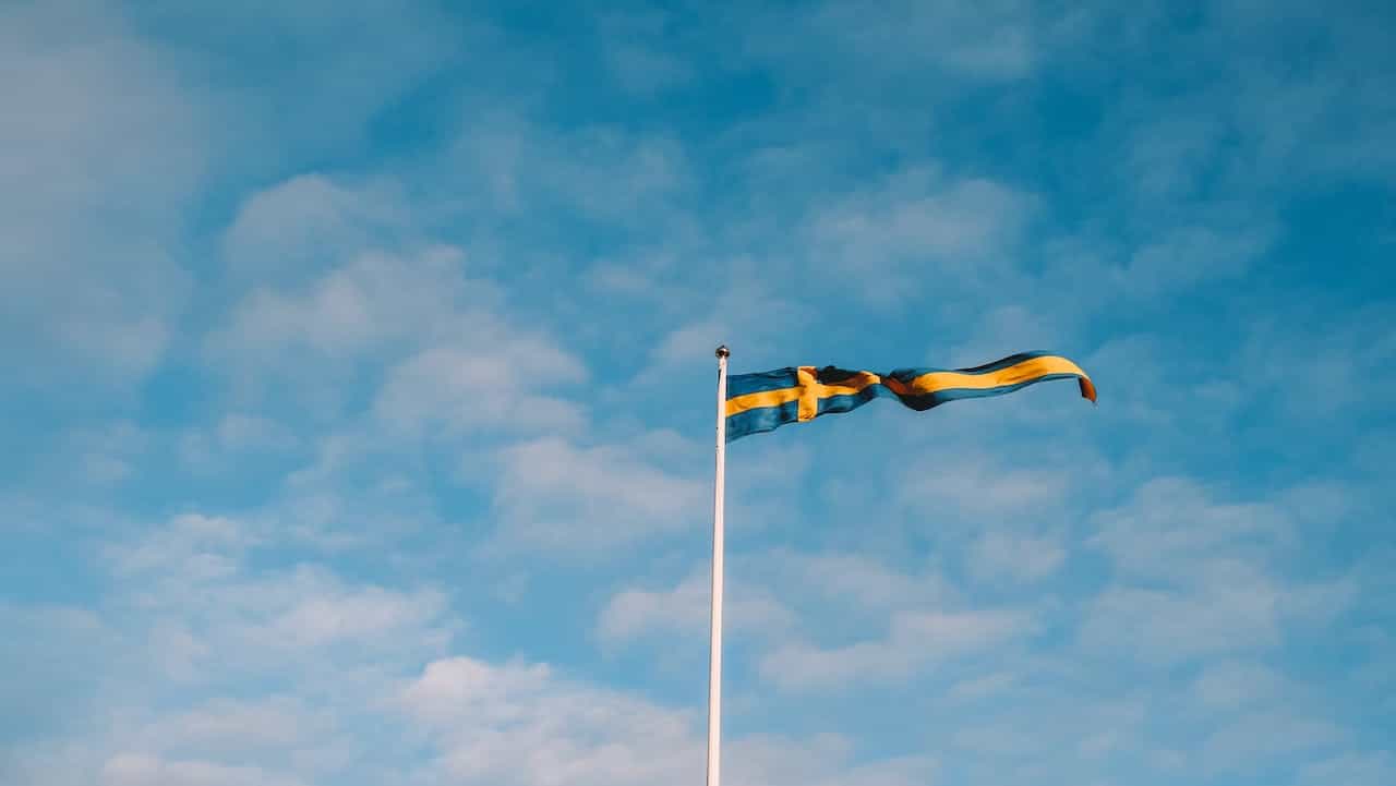 A blue and yellow flag against a blue sky.