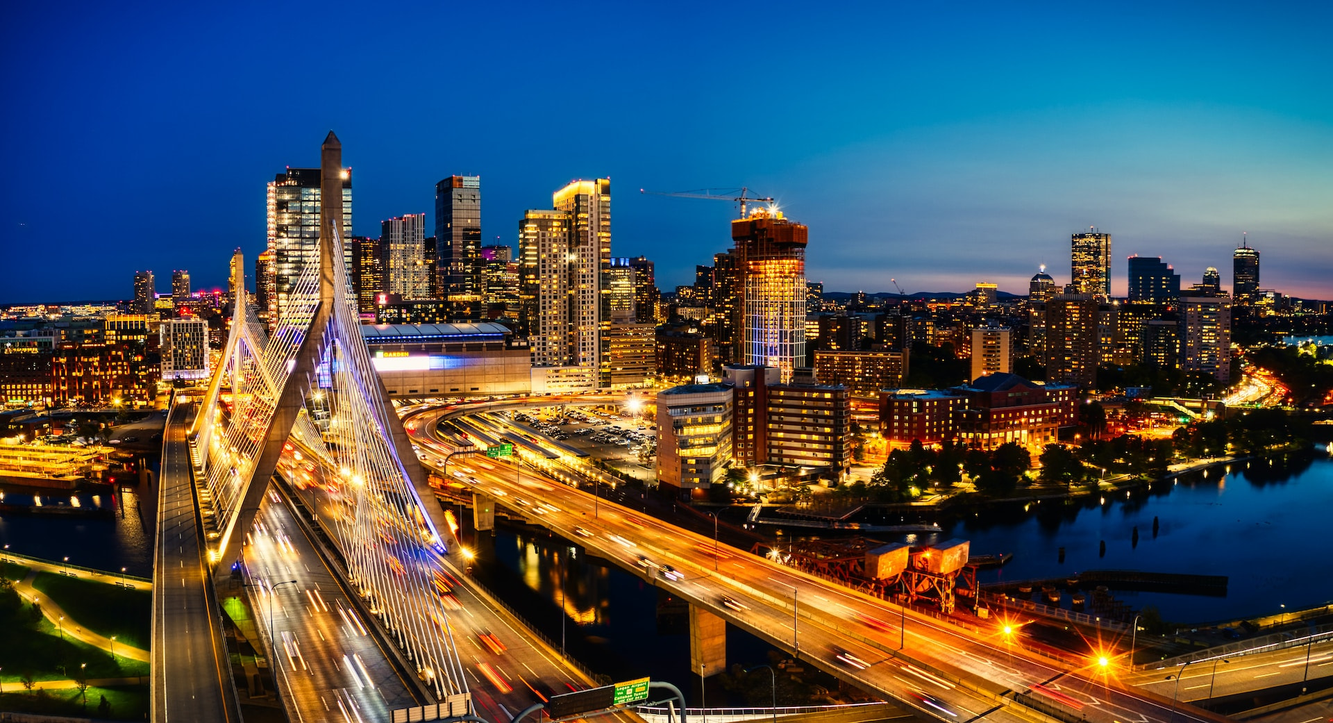 A view of downtown Boston in the state of Massachusetts featuring numerous skyscrapers and bridges crossing the Charles River.