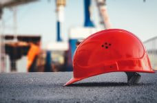 A worker’s hard hat helmet sitting on the ground of a construction site.