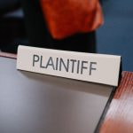 A sign displaying the word ‘plaintiff’ in a court of law during a lawsuit trial.