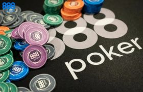 Chips and cards stacked on an 888poker branded poker table.