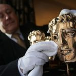 A BAFTA trophy gets a quick polish from an official.