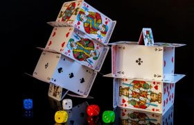 An image showing card towers and colourful dice.