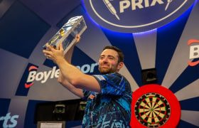 Luke Humphries lifts his 2023 World Grand Prix winner’s trophy.