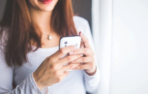 A Woman Playing Casino Games on Her Mobile Phone