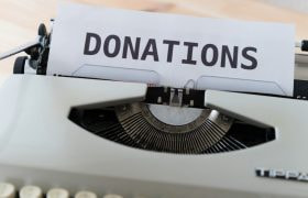 A Typewriter with the Word 'Donations' on Paper.