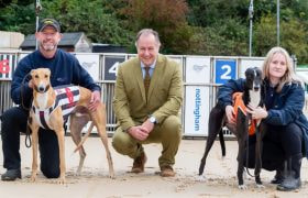 GBGB Chief Executive Mark Bird flanked by two racing greyhounds and their handler