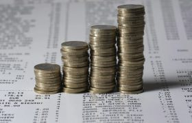 А Pile of Pound Coins Over Receipts