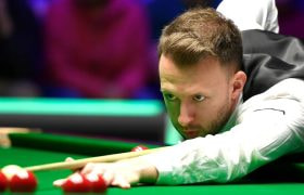 Snooker star Judd Trump lines up a shot.