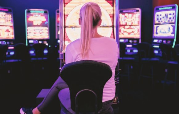 A Woman sitting at Slot machine in a Casino