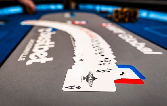 A deck of cards neatly spread in order across a poker table.