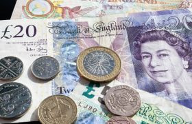 Various British coins on top of bank notes