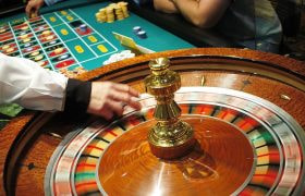 A Roulette Wheel Spins as Chips Are Placed on a Table Layout