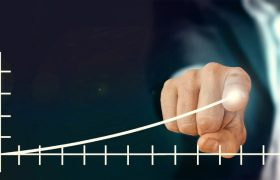 A Chart with a Human Hand Showing an Upward Trend