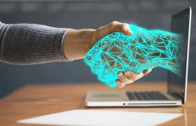 Handslag med en futurisk hand som kommer ut ur datorskärm