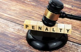 Penalty text on a wood block with gavel and block.